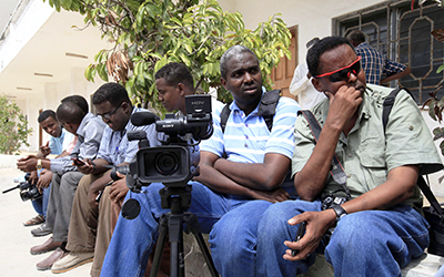 Somali journalist wait during an assignment at the Presidential Palace in Mogadishu