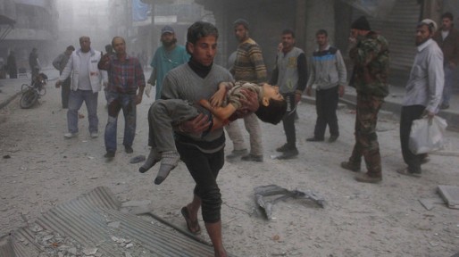 A man carries a child, injured by what activists said were barrel bombs dropped by warplanes loyal to Syria's President Assad, in Aleppo