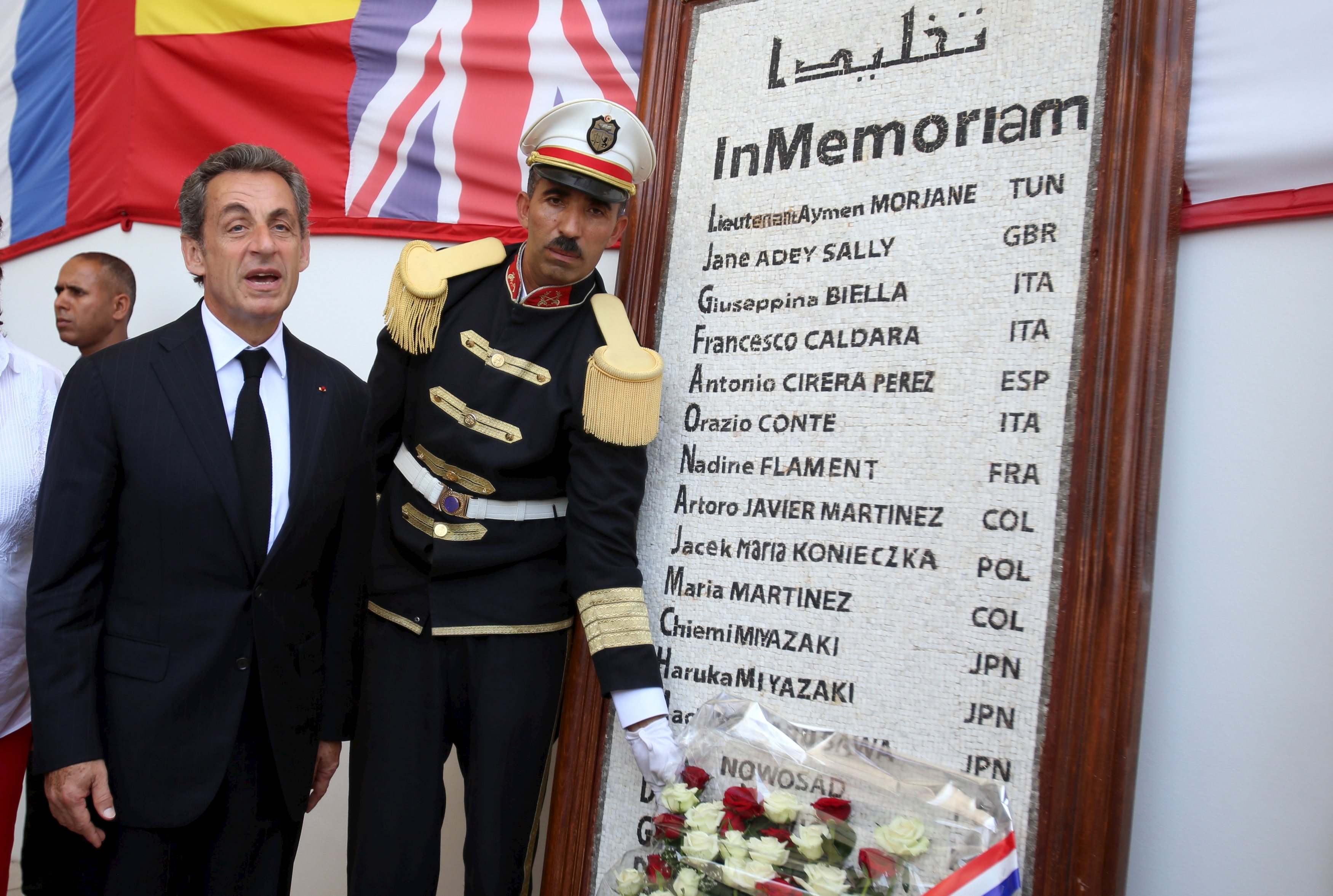 Former French President and head of the conservative Les Republicains party Nicolas Sarkozy (L) pays tribute to the victims of a militant attack on the Bardo Museum, in front of a memorial bearing their names, at the entrance of the museum in Tunis, Tunisia July 20, 2015. In March, two gunmen killed 21 people at the Tunis Bardo museum, before they were also shot.  REUTERS/Zoubeir Souissi